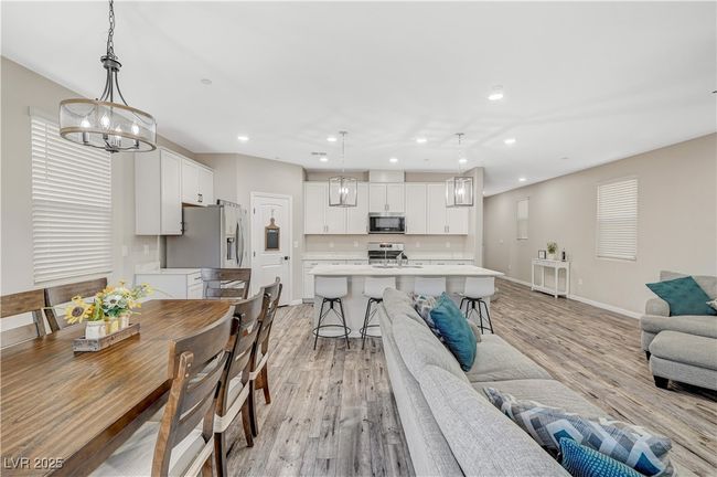 Living area featuring recessed lighting, light wood finished floors, baseboards, and a chandelier | Image 26