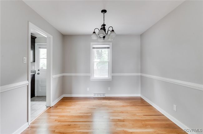 Unfurnished room with a chandelier, plenty of natural light, and light wood-style flooring | Image 5