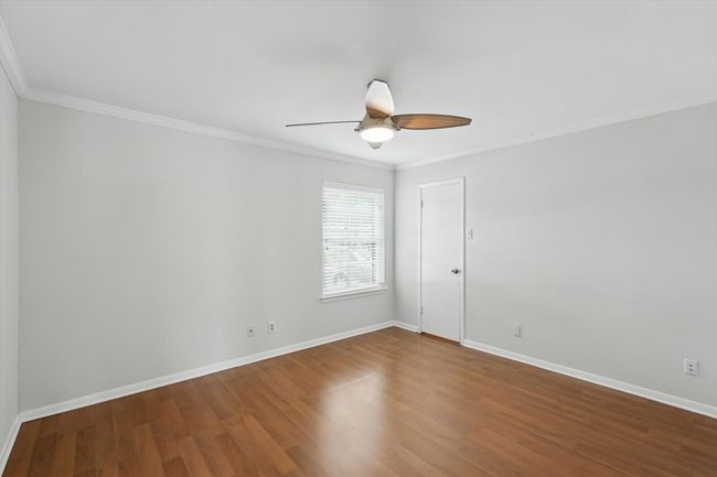 Unfurnished room featuring a ceiling fan, crown molding, wood finished floors, and baseboards | Image 5
