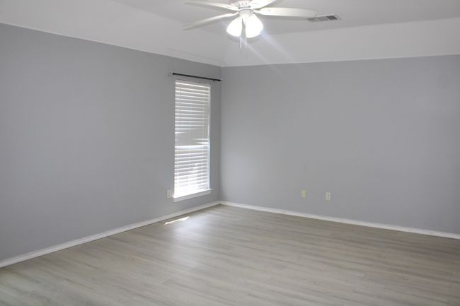 Unfurnished room featuring light wood-type flooring, baseboards, a ceiling fan, and visible vents | Image 21