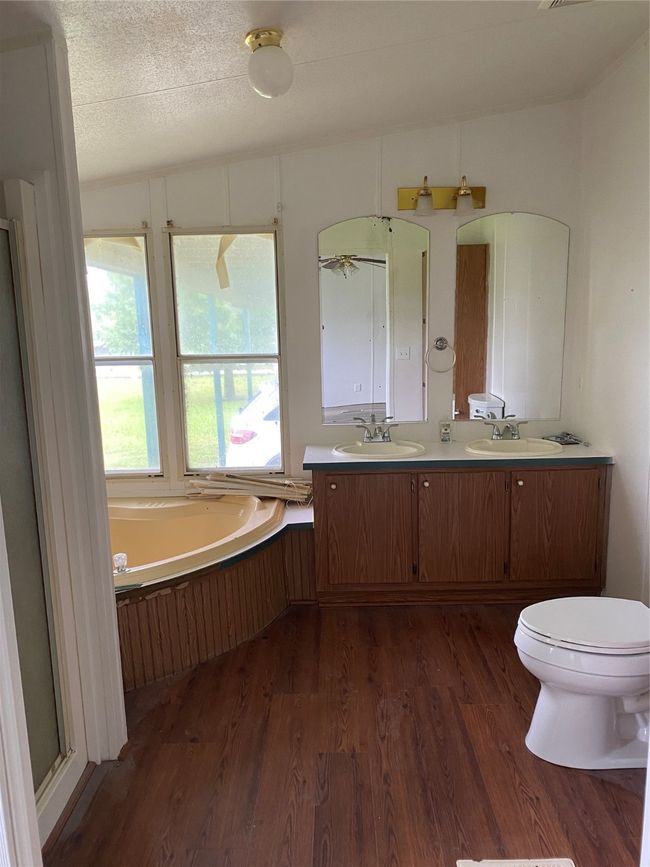 Full bathroom with wood finished floors, a garden tub, and double vanity | Image 12