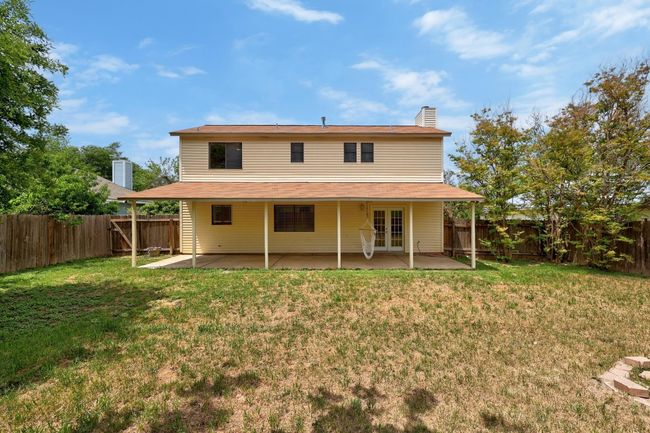 Back of house featuring a fenced backyard, a yard, a patio, and french doors | Image 23