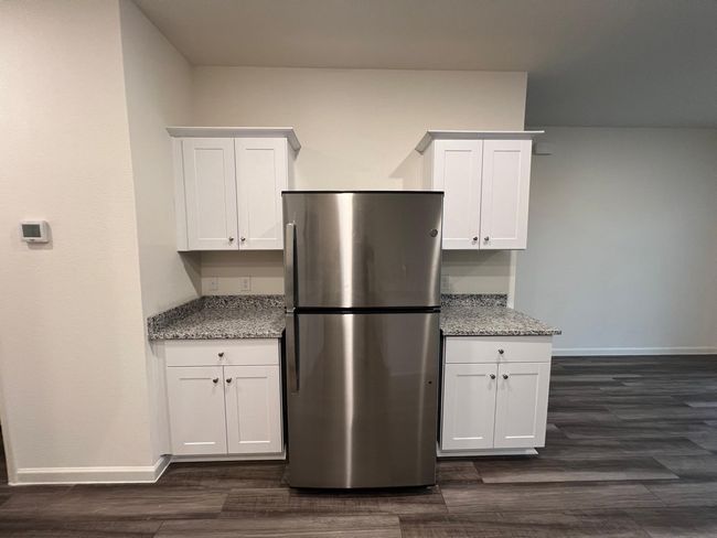 Kitchen featuring freestanding refrigerator, baseboards, and white cabinetry | Image 5