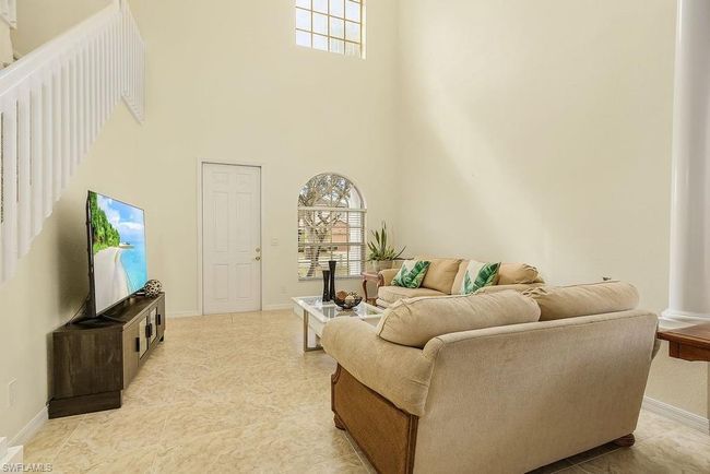 Living area featuring a high ceiling, plenty of natural light, and baseboards | Image 27