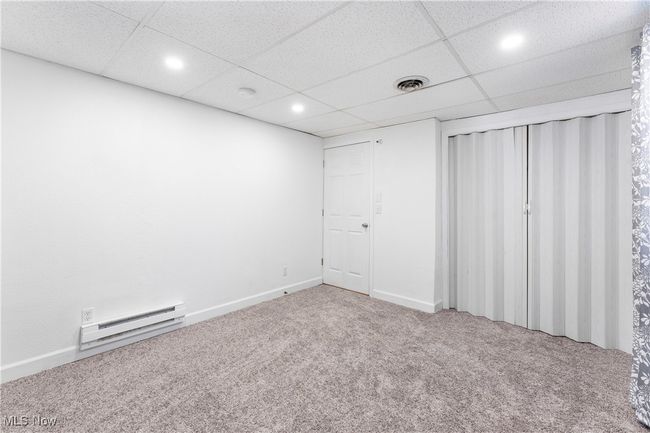 Unfurnished bedroom featuring visible vents, a baseboard heating unit, carpet floors, recessed lighting, and a paneled ceiling | Image 20