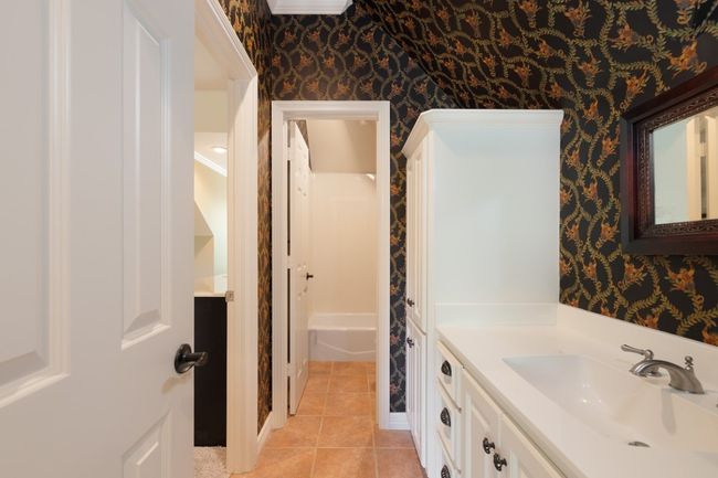 Bathroom featuring wallpapered walls, tile patterned flooring, and vanity | Image 27