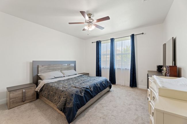 Bedroom featuring light colored carpet, ceiling fan | Image 20