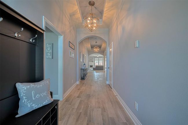 This inviting one-story floor plan features a long foyer that warmly welcomes guests into the home. Wood Plank Tile floor was added in 2022. | Image 4