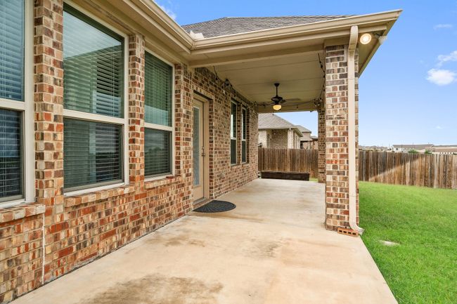 Fenced backyard with a patio and a ceiling fan | Image 29