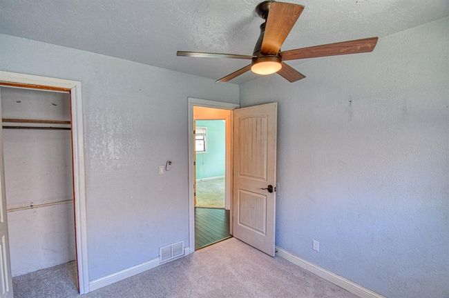 Unfurnished bedroom featuring carpet flooring, a closet, baseboards, and a ceiling fan | Image 22