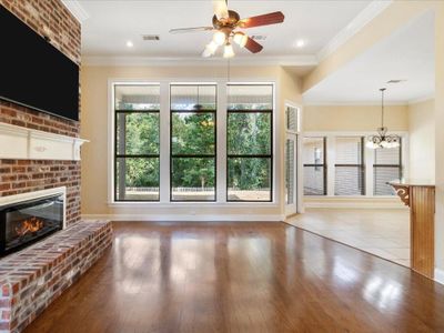 Living area includes electric fireplace, with TV over the mantel with a wall of windows overlooking the Lake Ramsey Nature Preserve. | Image 2