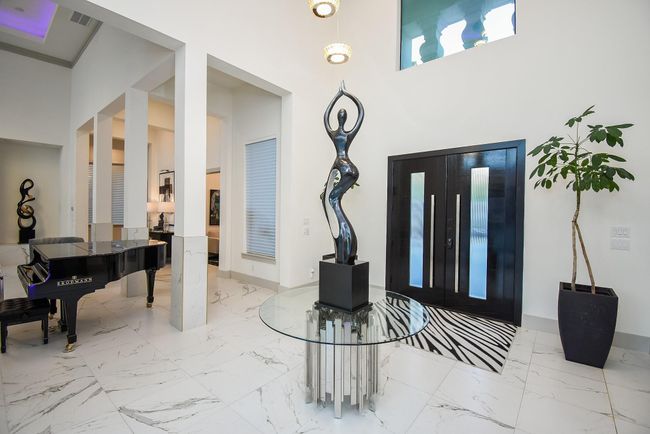 Elegant entryway with high ceilings. All window coverings throughout home are motorized. 24 inch Boreas Porcelain tile flooring throughout the home. | Image 8