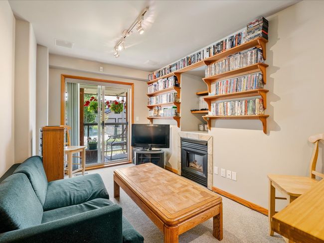 Carpeted living area with visible vents, a tile fireplace, and track lighting | Image 19