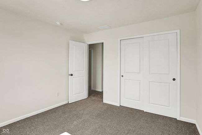 unfurnished bedroom featuring a closet, baseboards, and dark colored carpet | Image 31