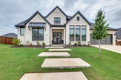 View of front of property featuring a garage and a front lawn | Image 1