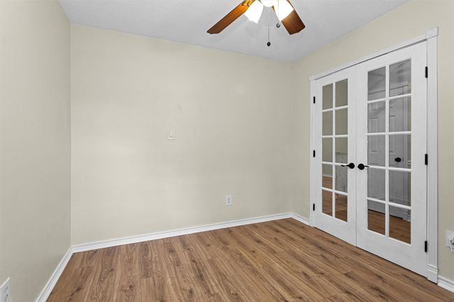 Ideal for remote work or quiet study, this dedicated home office features elegant French doors that provide both privacy and style. Natural light flows through the glass panes, creating a bright and inspiring workspace while maintaining a sense of openness. Whether used as a study, library, or creative space, this versatile room offers comfort and sophistication. | Image 14