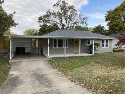 View of front of home featuring a porch, a front lawn, and a carport | Image 1