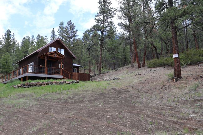 View of front of property featuring a wooden deck and a wooded view | Image 20