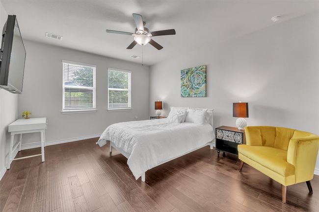 Bedroom with wood finished floors, baseboards, and ceiling fan | Image 8