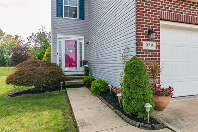 Doorway to property featuring a lawn and a garage | Image 2