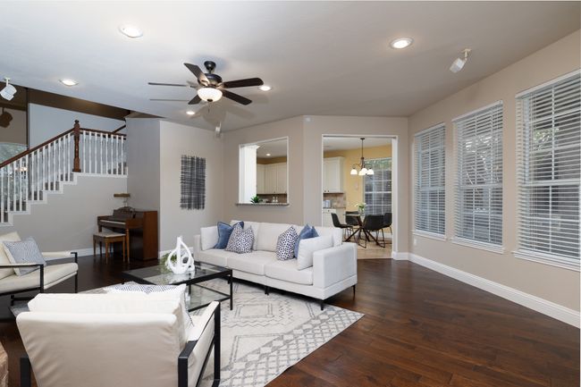 Living room featuring dark wood-style floors, ceiling fan, stairs, recessed lighting, and a chandelier | Image 12