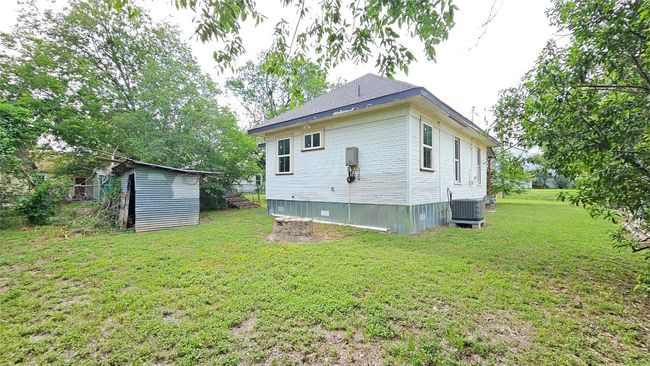 Back of house featuring central AC, a lawn, and an outdoor structure | Image 11