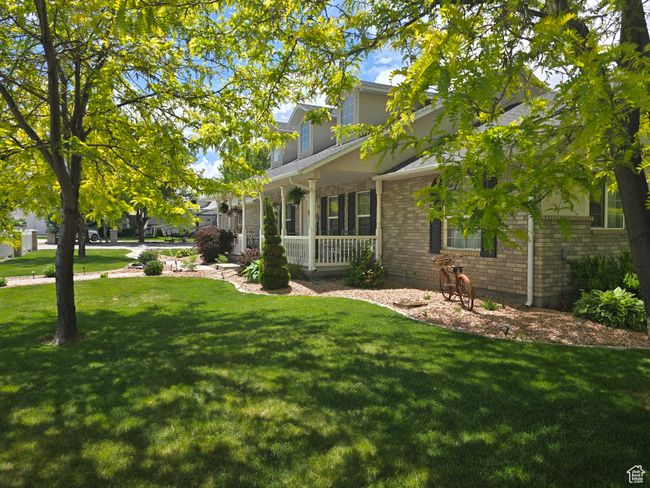 View of property exterior with a porch, a lawn, and brick siding | Image 79