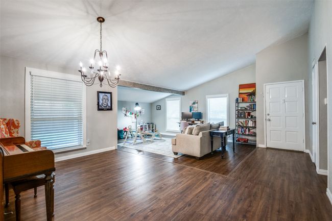 Living room featuring a chandelier, dark wood-style flooring, and lofted ceiling | Image 11