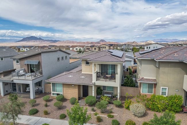 Rear view of house with stucco siding, a mountain view, a balcony, and a residential view | Image 5