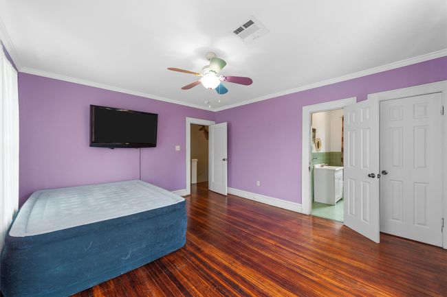 Unfurnished bedroom with ornamental molding, wood finished floors, ceiling fan, and connected bathroom | Image 28