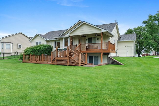 Rear view of house with ceiling fan, stairs, a shingled roof, and a wooden deck | Image 26