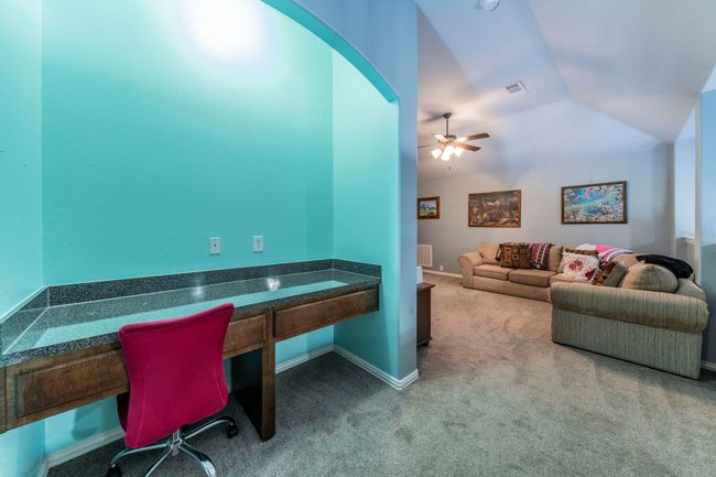 Office with carpet flooring, a ceiling fan, vaulted ceiling, baseboards, and radiator | Image 23