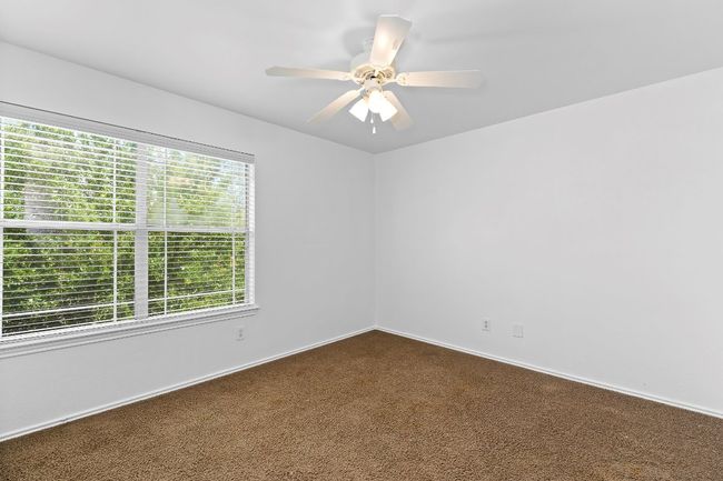 Empty room featuring dark colored carpet and ceiling fan | Image 24
