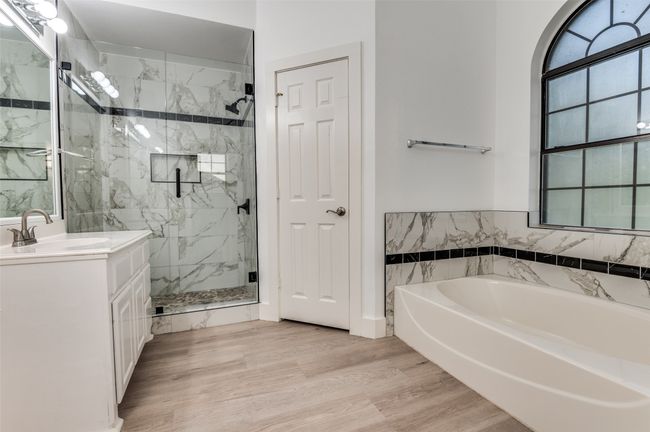 Bathroom featuring a marble finish shower, a bath, vanity, and wood finished floors | Image 18