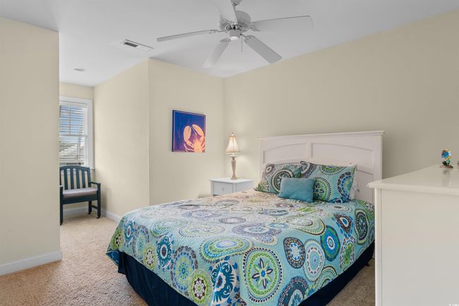 Bedroom featuring light colored carpet, baseboards, and ceiling fan | Image 21