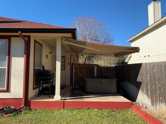 Covered patio extended with retractable awning over hot tub. | Image 6