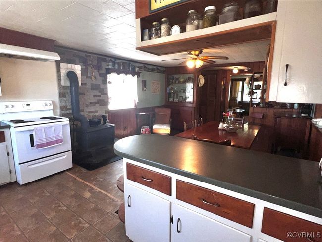 Kitchen with extractor fan, a wood stove, ceiling fan, and electric range | Image 20
