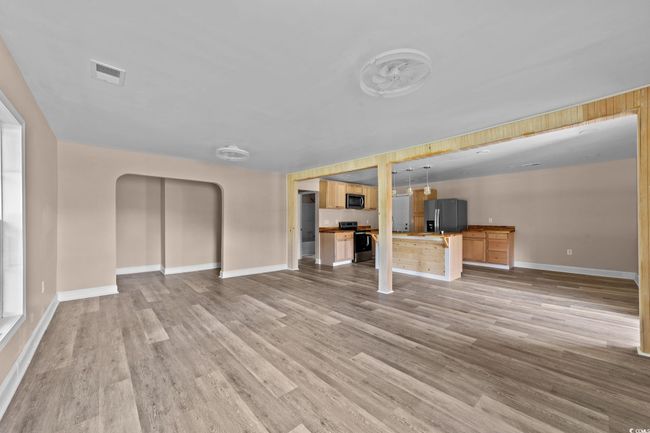 Unfurnished living room featuring arched walkways and light wood-type flooring | Image 20