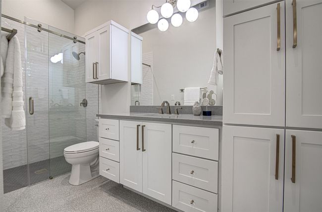 Full bath featuring a shower stall, vanity, and toilet | Image 15