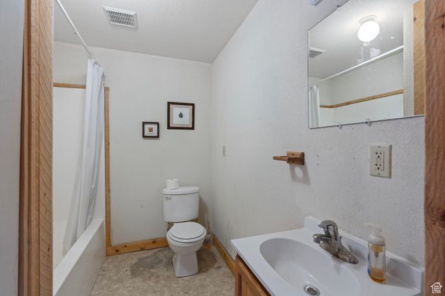 Full bathroom with vanity, toilet, and shower / bath combo with shower curtain | Image 12