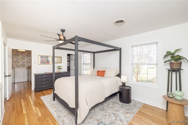Bedroom with a ceiling fan, light wood finished floors, washer / clothes dryer, baseboards, and visible vents | Image 17
