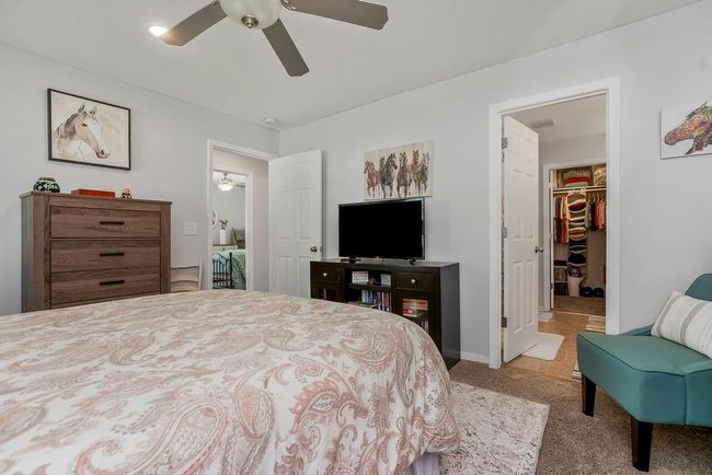 Bedroom with a walk in closet, ceiling fan, a closet, and carpet | Image 18