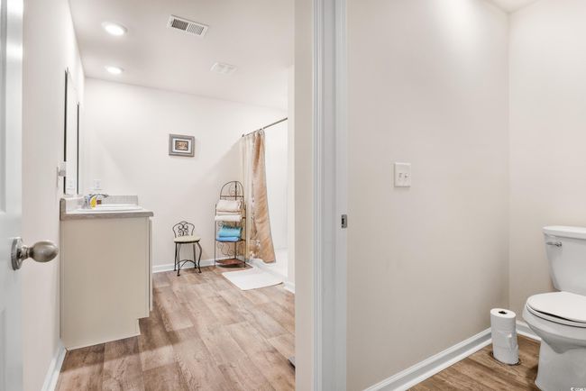 Bedroom featuring light colored carpet, baseboards, ensuite bathroom, and ceiling fan | Image 27