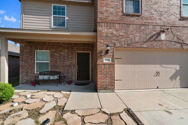 Property entrance featuring an attached garage, brick siding, and concrete driveway | Image 6