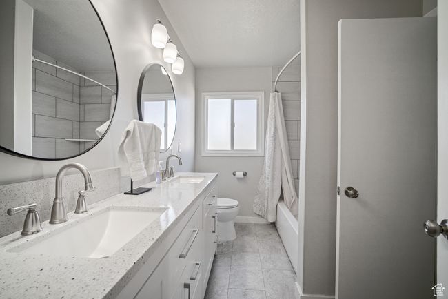 Full bathroom with shower / tub combo, double vanity, toilet, and baseboards | Image 10
