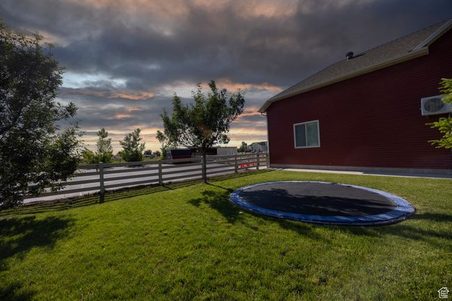 Yard at dusk featuring a trampoline | Image 65