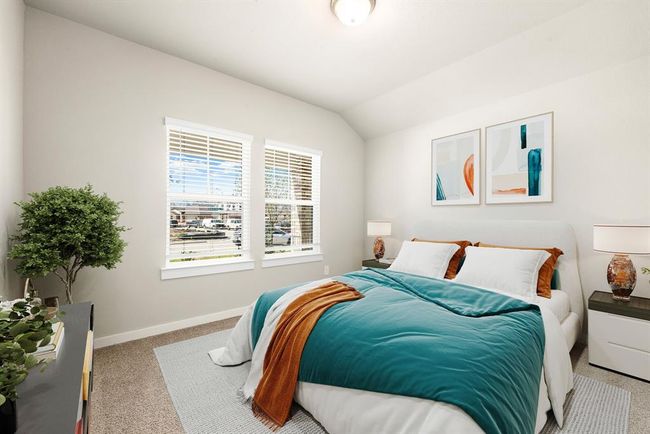 Secondary bedroom features plush carpet, neutral paint, lighting and a large window with privacy blinds. | Image 15