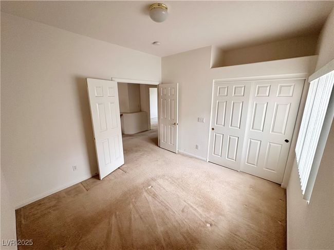 Unfurnished bedroom with light colored carpet, a closet, and baseboards | Image 13