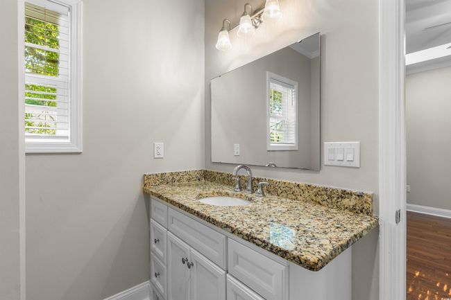 Bathroom featuring healthy amount of natural light, vanity, baseboards, and wood finished floors | Image 17