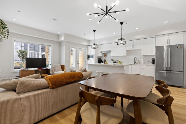 Living room featuring recessed lighting, an inviting chandelier, light wood-style floors, and a healthy amount of sunlight | Image 12